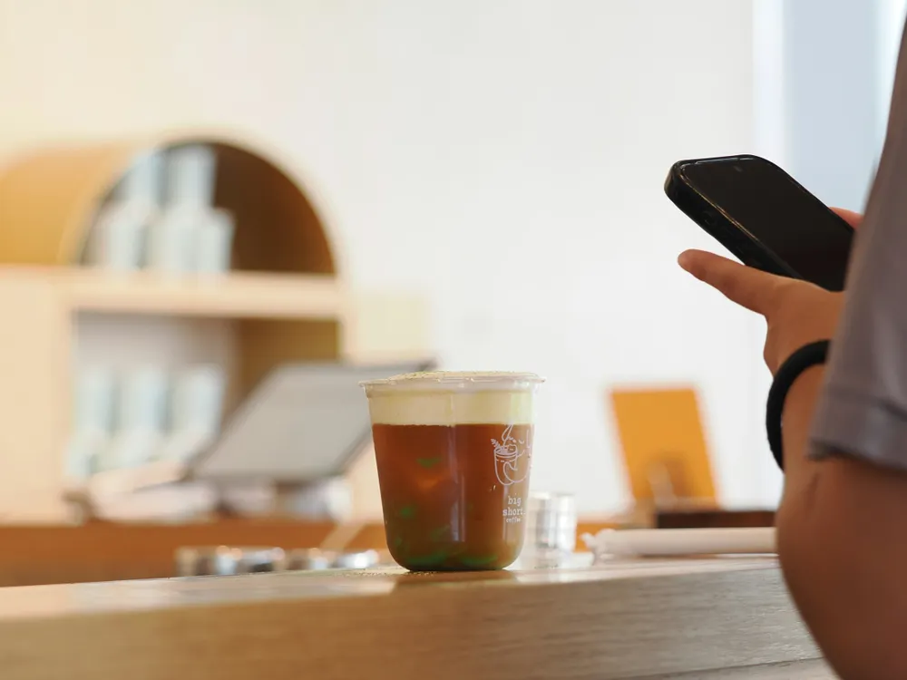 Clean retail counter with smartphone showing MobiBiz app