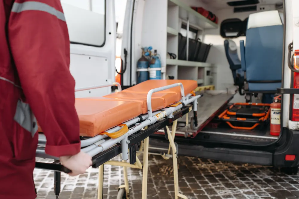 Medical team loading stretcher into ambulance during flood relief