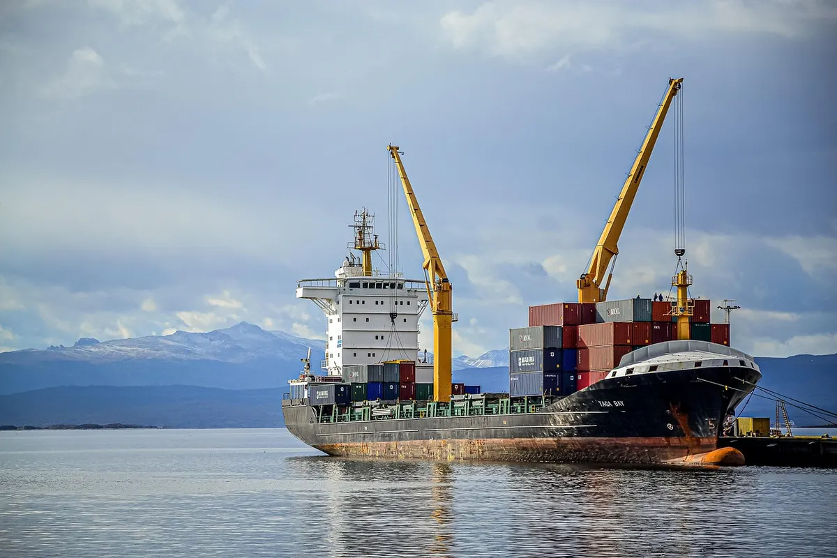 Global cargo ship at a busy port terminal