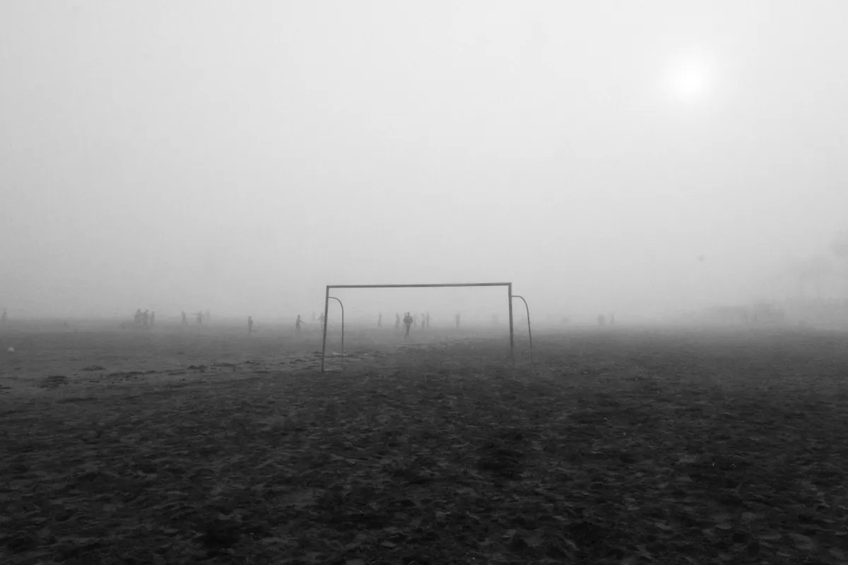 Wide-angle shot of green soccer pitch at dawn