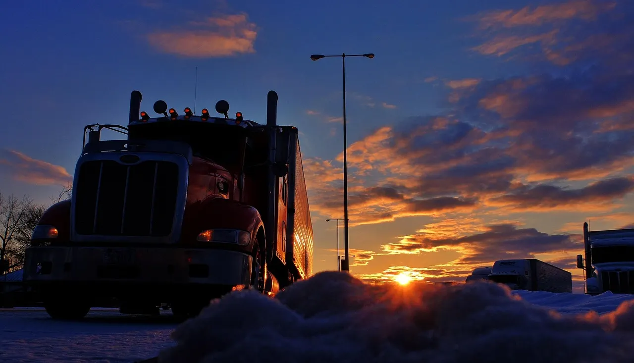 Heavy duty truck on coastal road at sunrise
