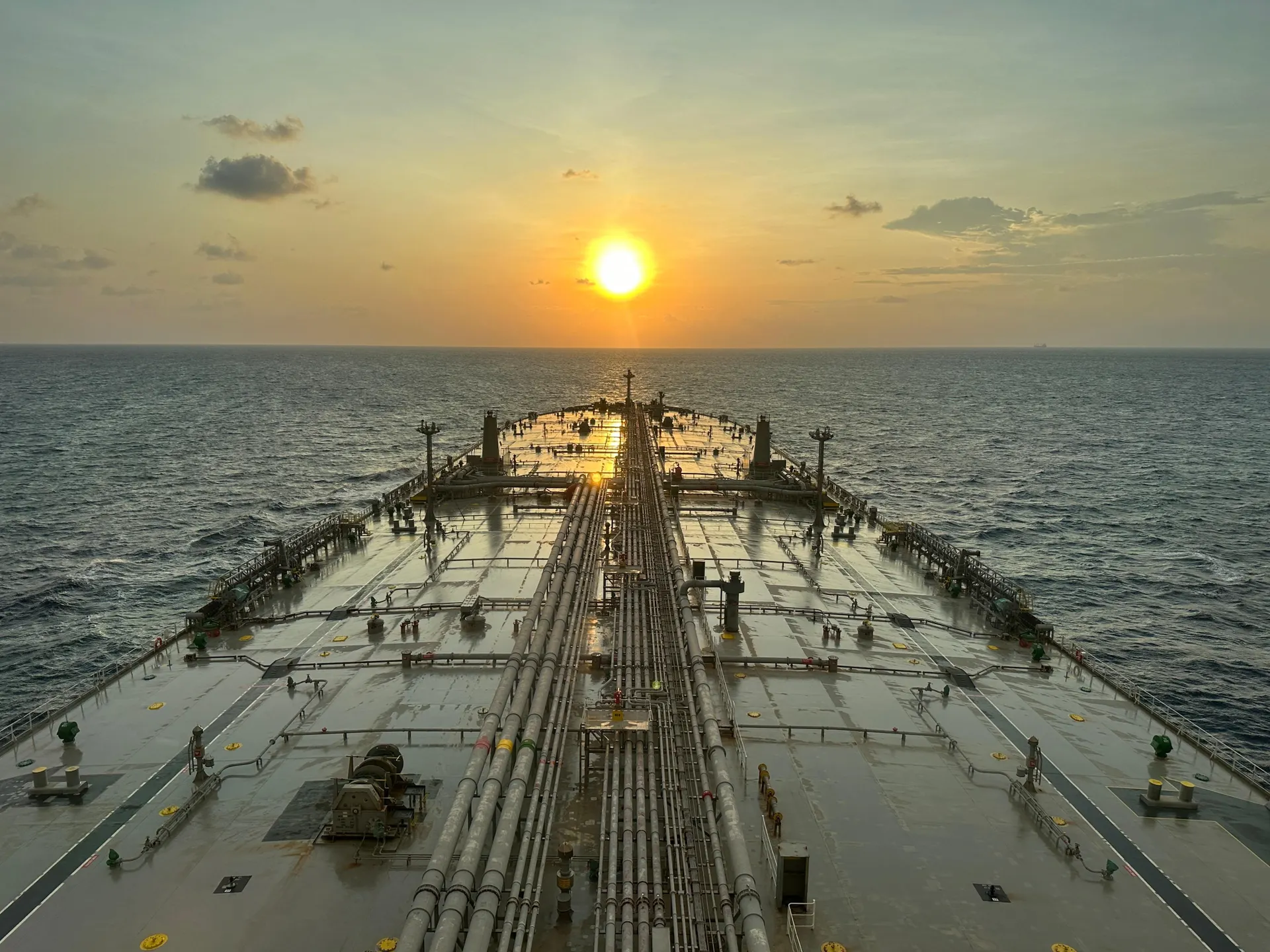 Large oil tanker sailing on the ocean with a sunset view