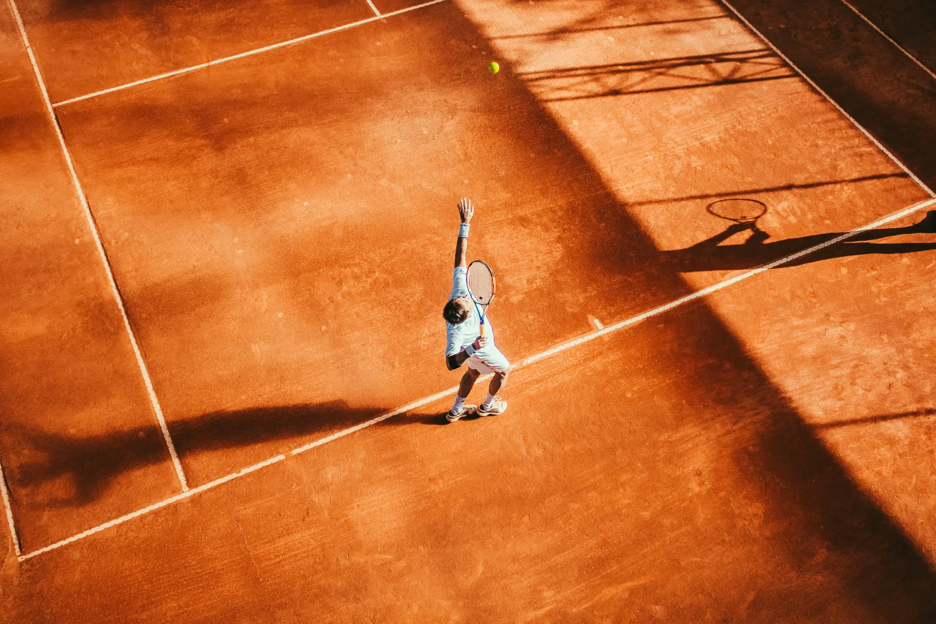 Tennis player mid-serve representing grit and grace