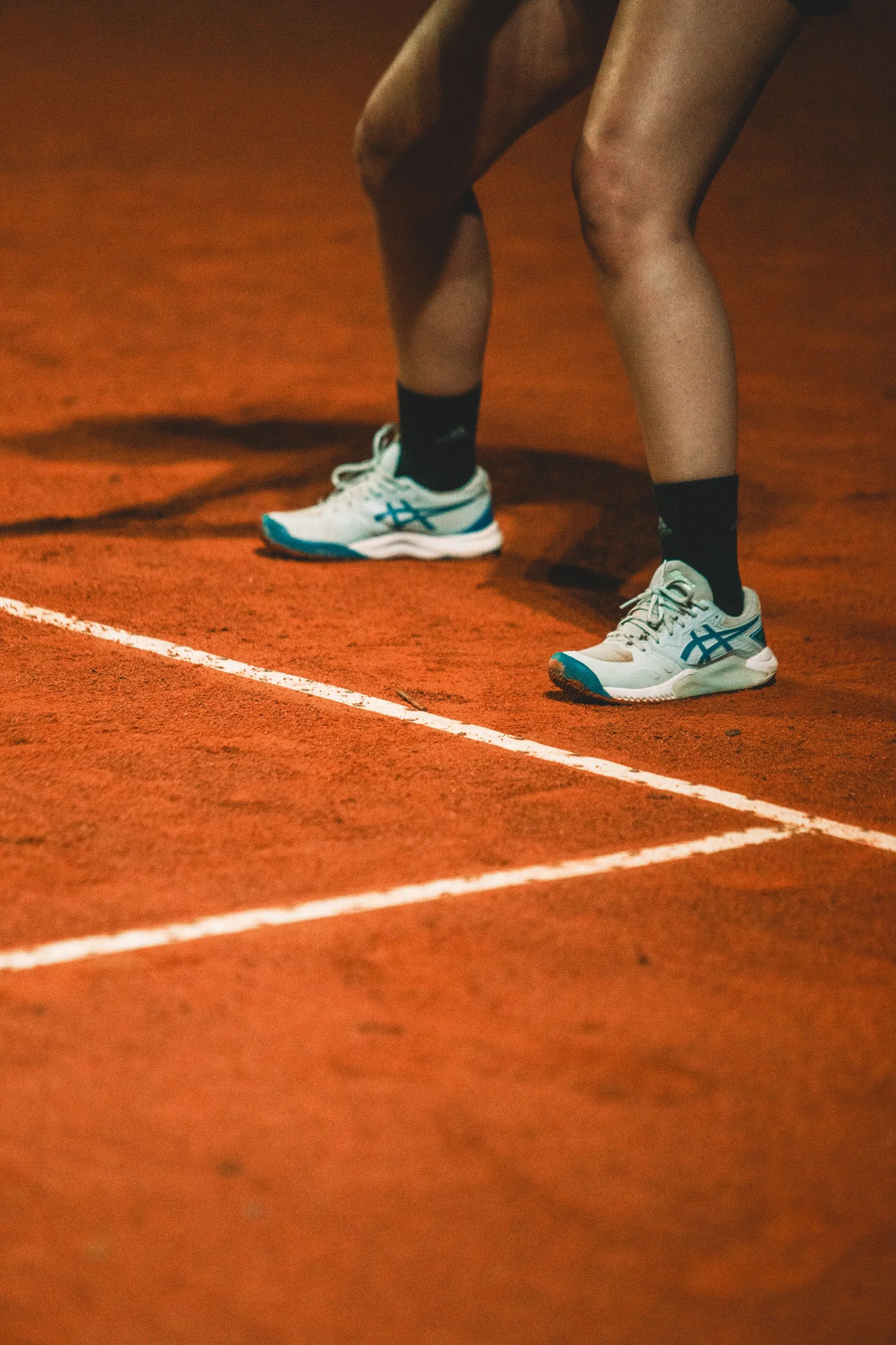 Close-up of tennis shoes on clay court ready for movement