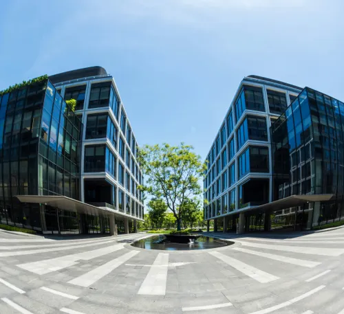 Modern office buildings flanking a central green courtyard