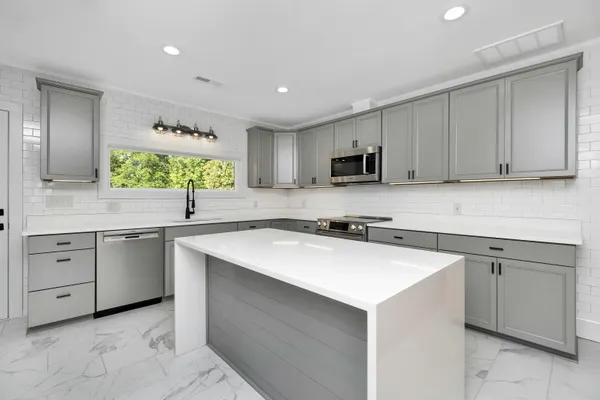 Modern luxury kitchen with grey cabinets and marble look sintered stone worktops