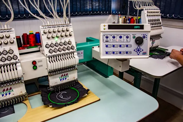 Industrial embroidery machine in a textile workshop specialized in school logo stitching