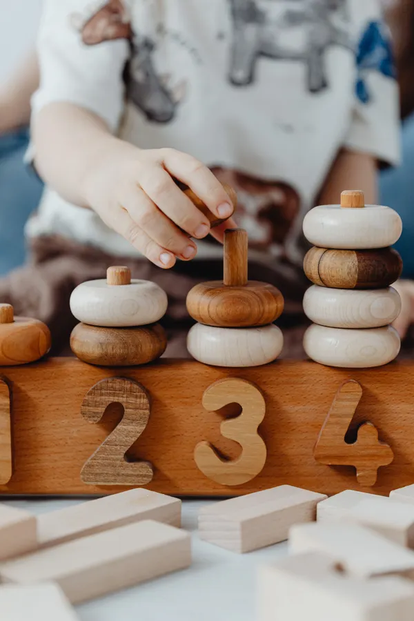 Child interacting with educational wooden Montessori blocks
