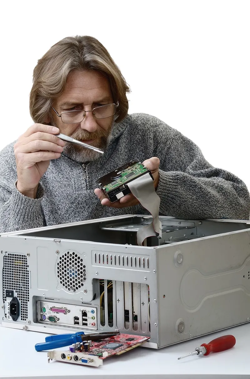 Technician hands repairing a laptop circuit board with precision tools