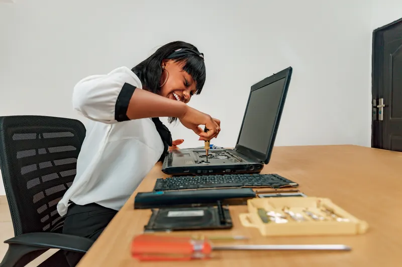 Professional technician repairing a laptop with precision tools