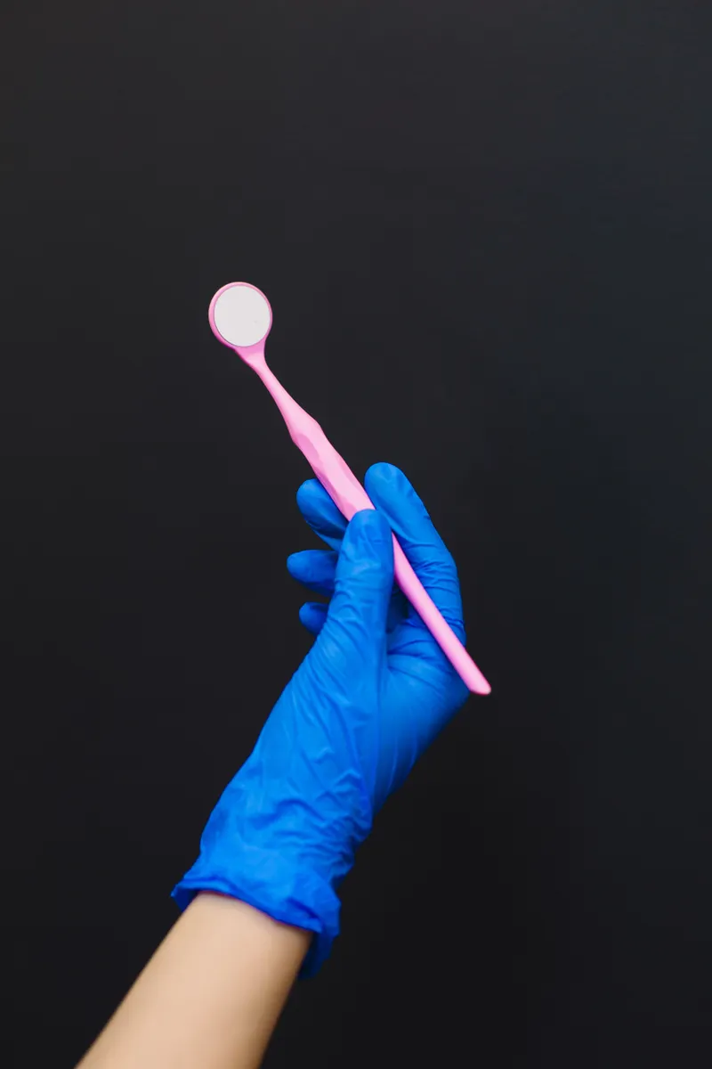 Close-up of a gloved hand inspecting a wand massager