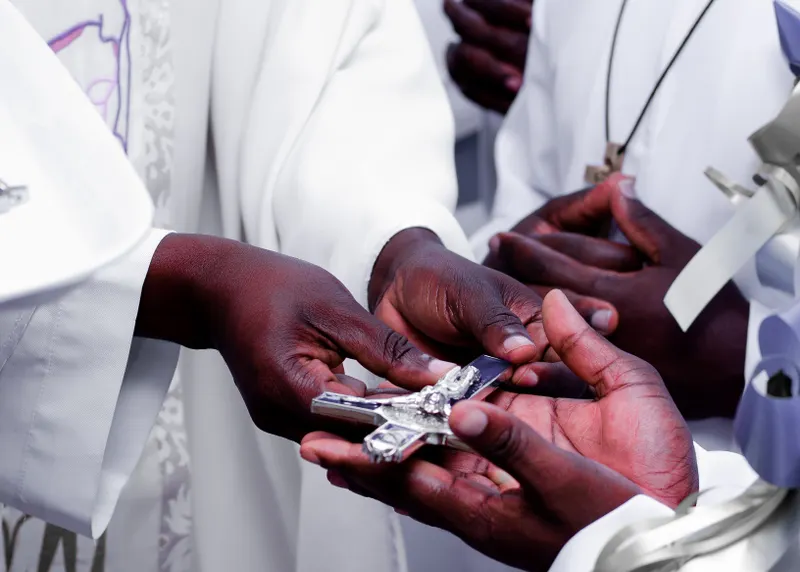 Priests exchanging a cross