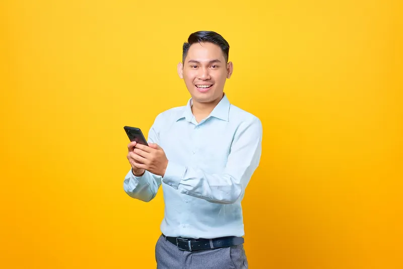 Professional businessman smiling while checking smartphone